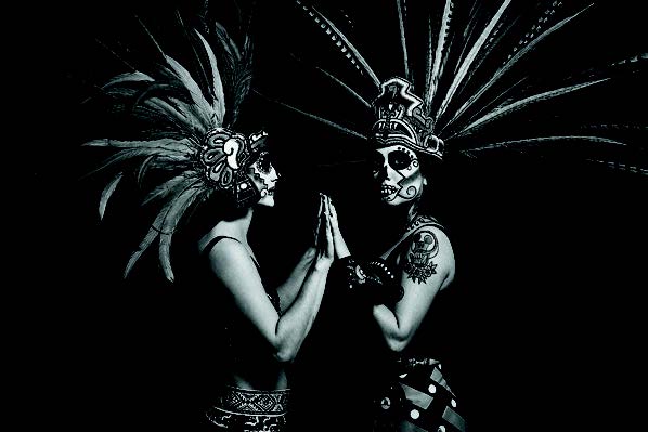 Cara Romero photograph Arla Lucia featuring figures in Aztec headdresses and calavera face paint honoring Indigenous traditions