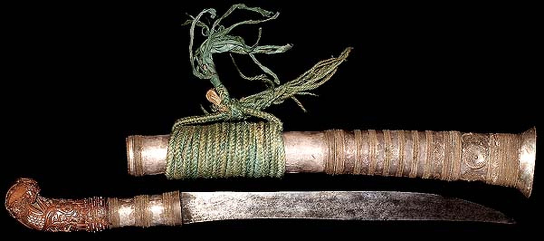 an Ifugao bear tooth knife with a curved handle and iron blade