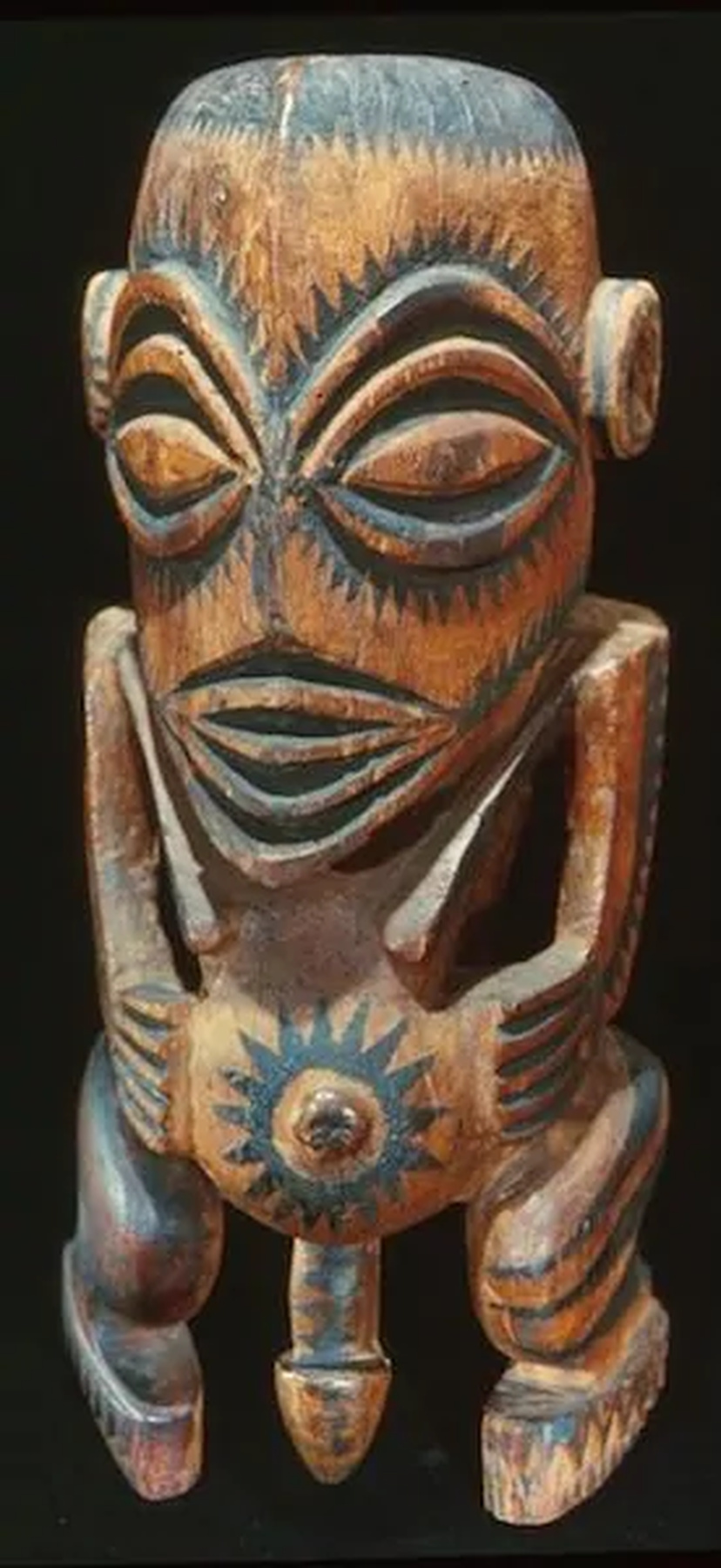 Marquesan tiki sculpture carved from volcanic stone, representing a seated human figure