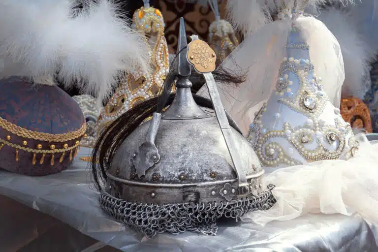 Traditional Kazakh metal warrior helmet with chainmail and ornate saukele bridal headdresses with pearl decorations